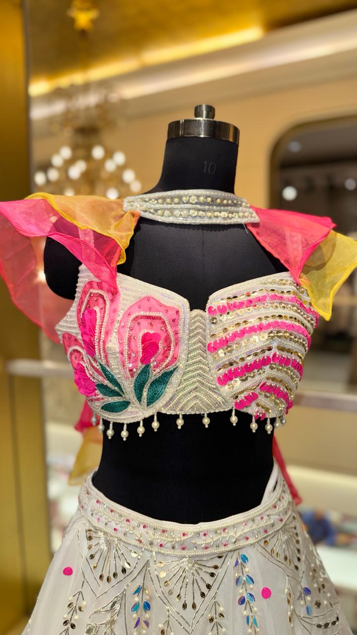 Designer Ivory Organza Lehenga with Candy Pink & Yellow 3D Appliqué and Ruffled Cape Sleeves